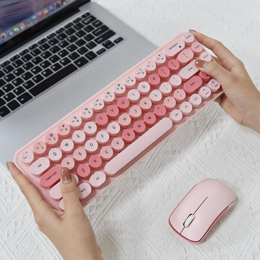 Wireless keyboard and mouse set in pink with a laptop